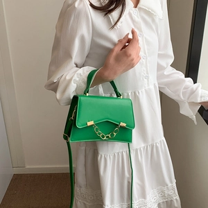 Chic green handbag with bold gold chain decoration and versatile crossbody strap