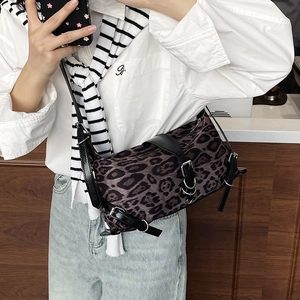 Trendy leopard print crossbody tote bag with black leather straps and metal buckles