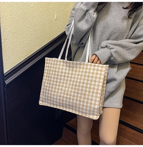 Detail view of yellow houndstooth pattern tote bag worn by a model on a shoulder
