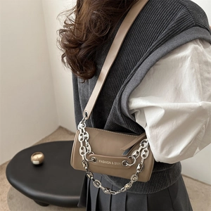 Retro brown cylinder crossbody bag with silver chain and adjustable strap on model