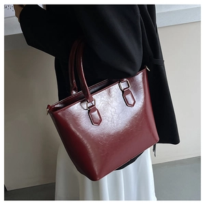 Deep burgundy glossy leather tote bag styled with a professional black blazer outfit
