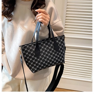 Detail view of the elegant geometric Monogram print on a stylish black women's tote bag