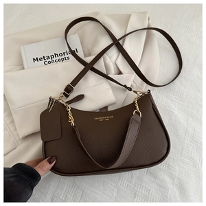 Macro shot of dark brown pebbled leather texture with elegant gold hardware on handbag