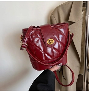Détails du sac seau matelassé rouge foncé avec son fermoir rotatif en métal doré