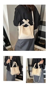 Detail view of cream lychee texture leather bucket bag with embossed Fashion lettering