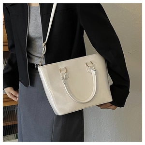 Chic cream white patent leather bucket bag shown with a model for a stylish lifestyle look