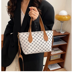Detail of printed tote bag with brown leather strap in a vintage interior scene