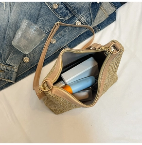 Detail of summer straw bag with brown leather trim showing spacious interior capacity