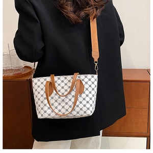 Rear view of model wearing a vintage floral tote bag with brown adjustable shoulder straps