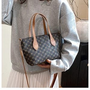 Detail of vintage patterned tote bag with brown leather handles and adjustable strap