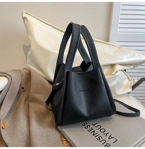 Close-up of black lychee leather bucket bag with fashion embossing and thick handle
