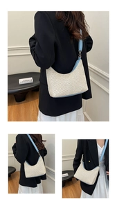 Detail of woven crescent shoulder bag with light blue leather strap for summer style