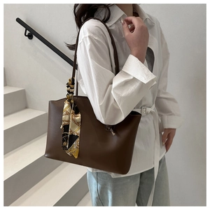 Dettaglio borsa tote grande marrone con sciarpa di seta decorativa a stampa geometrica