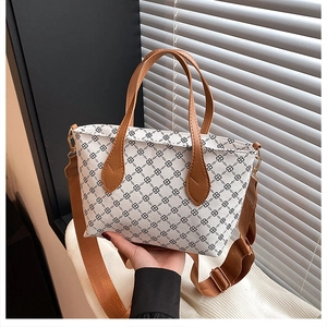Detail of vintage beige checkered tote with brown leather handles and adjustable strap
