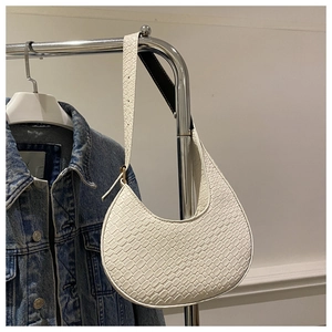 Detail view of white crescent bag with crocodile texture and adjustable strap