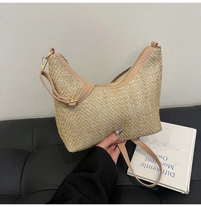 Close-up of woven texture and premium leather strap on the crescent straw shoulder bag