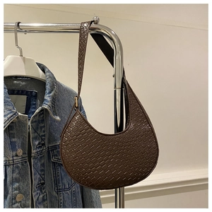 Detail of dark brown crescent hobo bag with crocodile pattern and adjustable gold buckle