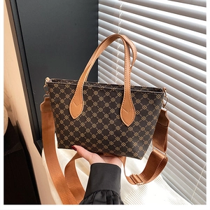 Close-up of vintage geometric print tote bag with brown leather handles and wide strap