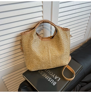 Close-up of woven straw handbag texture with brown leather straps on a minimalist setting