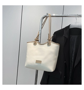Detail of white leather tote bag with knotted shoulder strap and Fashion label tag