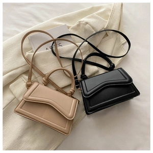 Detail of chic small crossbody bags with wavy flap and stylish knotted handles