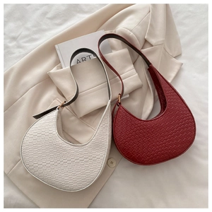Detail of woven texture leather crescent bags in beige and burgundy with adjustable straps