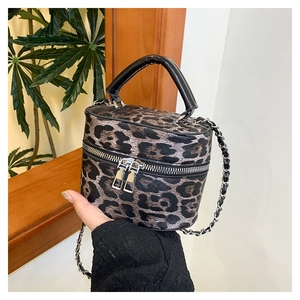 Close-up of leopard print cylinder bag with silver zippers and black leather handle