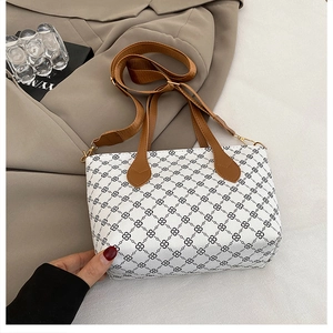 Detail view of floral printed tote bag with leather handles and wide canvas shoulder strap