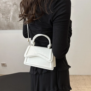 Minimalist white PU leather crossbody bag with unique wavy flap and twisted knot handle detail
