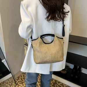 Fashionable woven straw shoulder bag with black leather trim and strap for summer beach travel