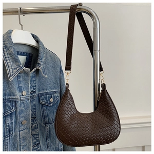 Detalle del bolso hobo trenzado marrón oscuro con ganchos de metal dorado