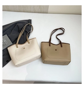 Detailed top view of two minimalist tote bags in cream and khaki on white fabric
