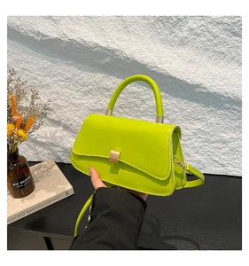 Dettaglio borsa in pelle verniciata verde neon con fibbia dorata e manico