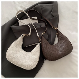 Vue détaillée de sacs demi-lune en cuir tressé avec boucles dorées sur blazer gris