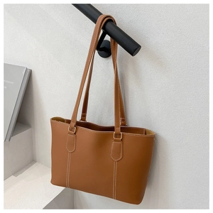 Close-up of brown tote bag featuring white contrast stitching and premium leather texture