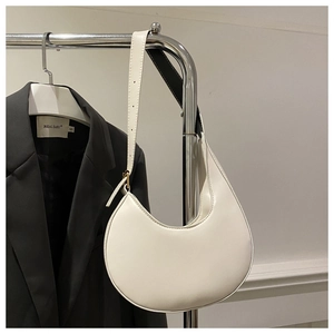 Detailed view of white leather crescent shoulder bag with adjustable strap and gold buckle