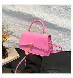 Dettaglio della borsa rosa con texture liscia e fibbia rettangolare in metallo dorato