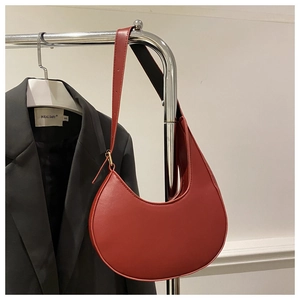 Detailed view of retro red crescent underarm bag showing fine stitching and leather texture