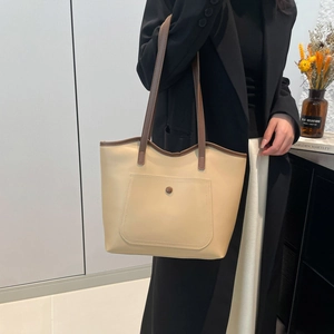 Minimalist cream and brown leather tote bag for women featuring a front pocket and button