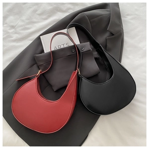 Top view of red and black matte PU leather crescent bags on a stylish backdrop