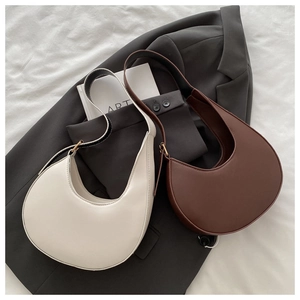 Detailed close-up of beige and brown hobo bags with golden hardware on a stylish background