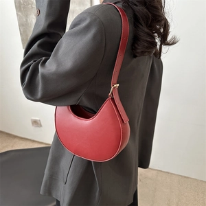 Minimalist red crescent moon shoulder bag in smooth faux leather with gold hardware