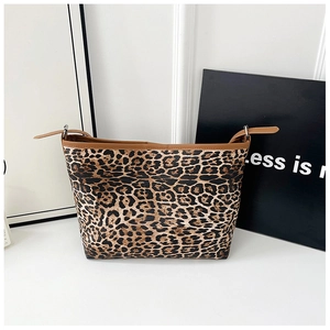 Détails du sac cabas imprimé léopard avec bordures en cuir marron et nœuds latéraux