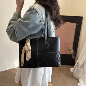 Fashionable black tote bag with checkered patchwork and elegant silk scarf decoration
