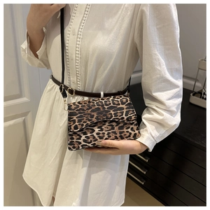 Dettaglio della borsa a tracolla leopardata alla moda con fibbie dorate sulla modella