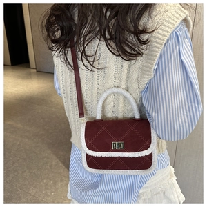 Rear view of model wearing a vintage burgundy crossbody bag with white shearling trim