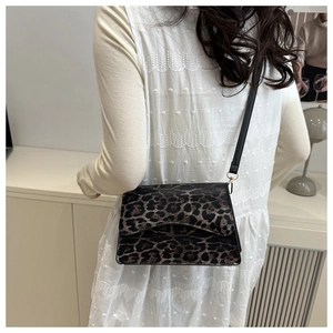 Dettaglio della borsa a tracolla con stampa leopardata e sottile cinturino in pelle nera