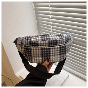 Close-up of black and white plaid waist bag featuring a durable canvas and nylon zipper