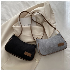 Detail of vintage canvas shoulder bags in black and grey with brown leather trim