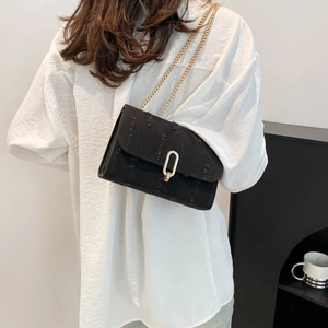 Denim patchwork crossbody chain bag with gold U-shaped lock shown on model